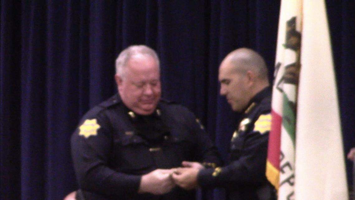 Fresno Police Chief Paco Balderrama hands Burke Farrah his badge as the Deputy Chief on Tuesday, Aug. 10, 2021.