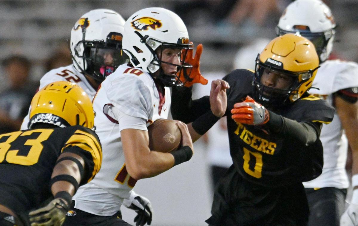 Clovis West quarterback Tyler Franklin, center, finds an opening as he scrambles against Edison Friday, Sept. 15, 2023 in Fresno.