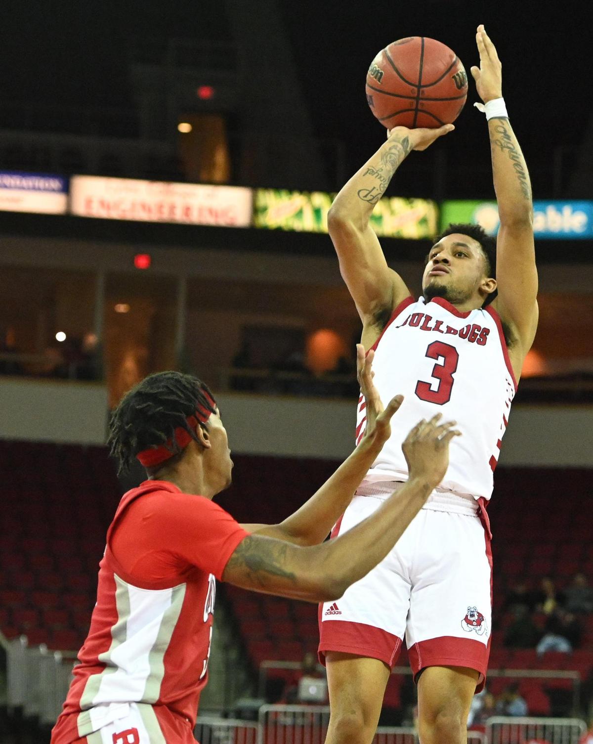 Fresno State’s Isaiah Hill, right, eyes a shot while defended by UNLV’s Donovan Williams during their game at the Save Mart Center in Fresno on Wednesday, Feb. 16, 2022.