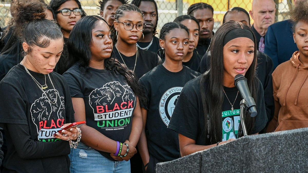 Simone Alford, representante de la Unión de Estudiantes Afroamericanos de Edison High School, a la derecha, se dirige a los reporteros el 9 de mayo de 2022, después de que cientos de estudiantes salieran de clase para protestar contra el persistente acoso en línea a estudiantes afroamericanos en Fresno durante el año escolar. Las tensiones alcanzaron su punto máximo después de que apareciera en línea una foto racista tomada en la sala de pesas de Bullard High. Muchos estudiantes afroamericanos afirmaron que el incidente fue simplemente el capítulo más reciente en décadas de un patrón de discriminación sistémica en las escuelas de la ciudad.