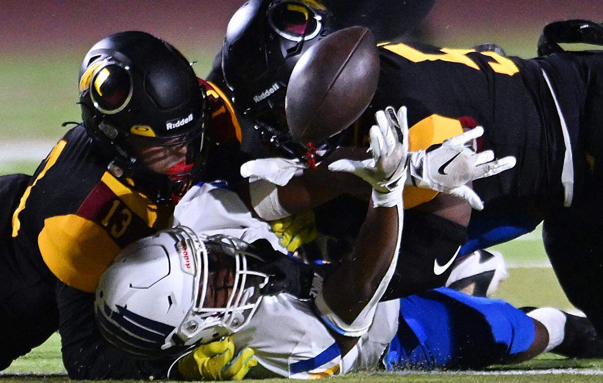 Bakersfield Christian's Richlyn Gooden, center, fumbles the ball leading to a Tulare Union recovery Friday, Sept. 26, 2025 in Tulare. Bakersfield Christian beat Tulare Union 30-7.