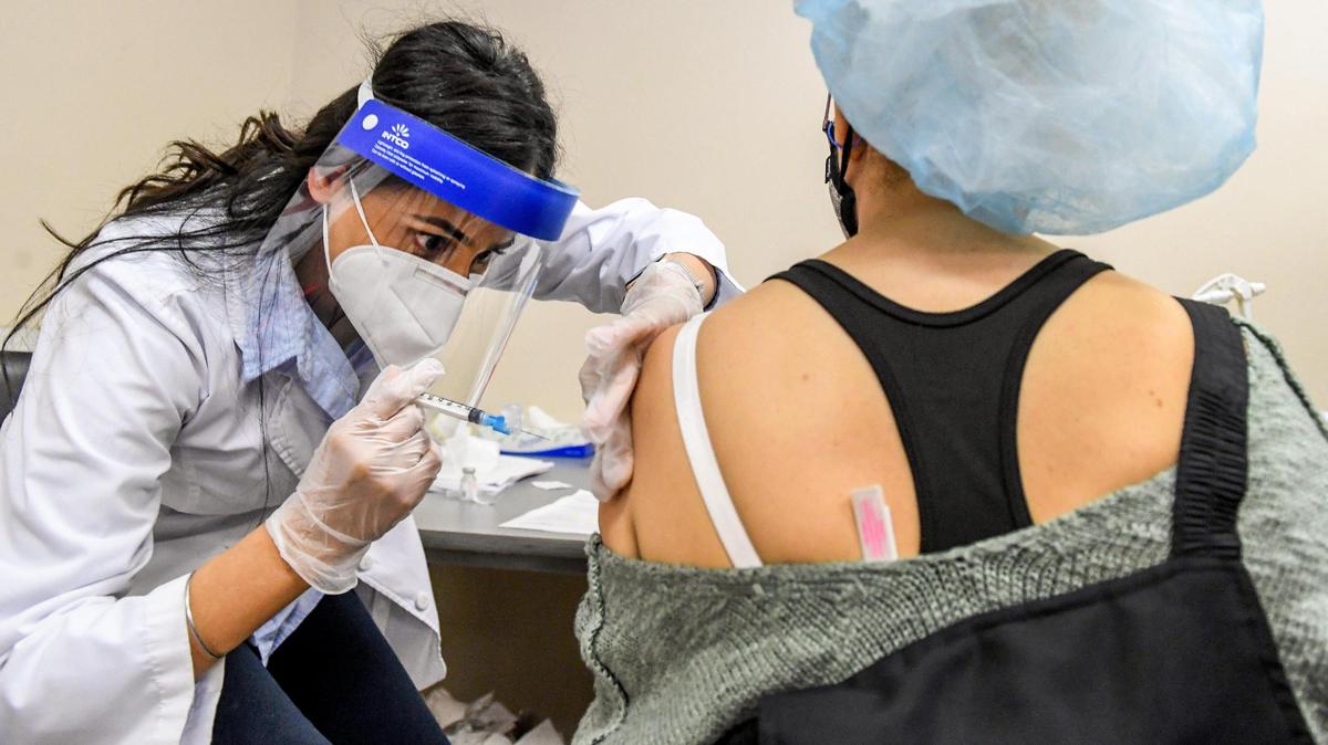 Vons pharmacist Navjot Bisla gets ready to administer a Moderna COVID-19 vaccination shot for Foster Farms employee Emma Erazo De Arteaga during a COVID-19 vaccine program for essential agricultural workers at the Foster Farms Cherry Avenue poultry plant in Fresno on Tuesday, Feb. 2, 2021.