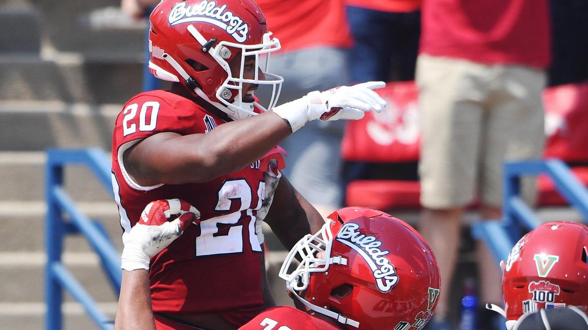 Fresno State’s Dontae Bull, bottom right, lifts Ronnie Rivers after Rivers scored a touchdown against UConn, making Rivers the school’s career TD leader Saturday, Aug. 28, 2021 in Fresno. The Bulldogs led 31-0 at halftime.