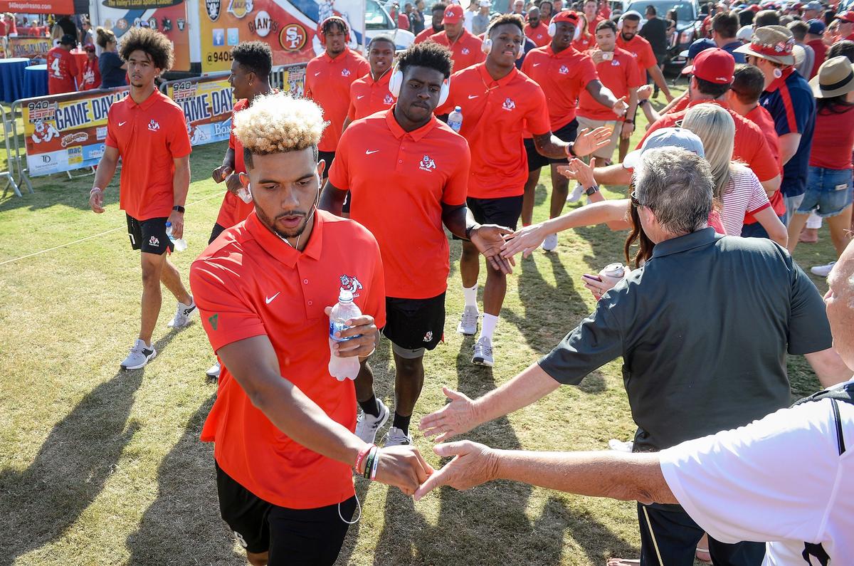 Fresno State quarterback Marcus McMaryion touches hands with fans as the Bulldogs are cheered on near the football tailgate area during their pregame march into Bulldog Stadium before playing Idaho on Saturday, Sept. 1, 2018. The Bulldogs won their season-opener 79-13.