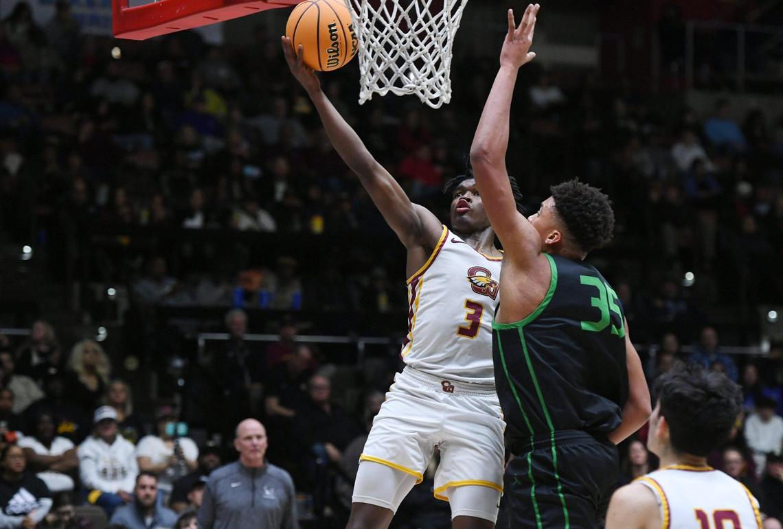 Clovis West’s Marshel Sanders, left, makes the layup guarded by St. Joseph’s Caedin Hamilton, right, in the Central Section boys Division I basketball championship Saturday, Feb. 25, 2023 in Fresno. St. Joseph won the championship beating Clovis West with a final score of 74-58.
