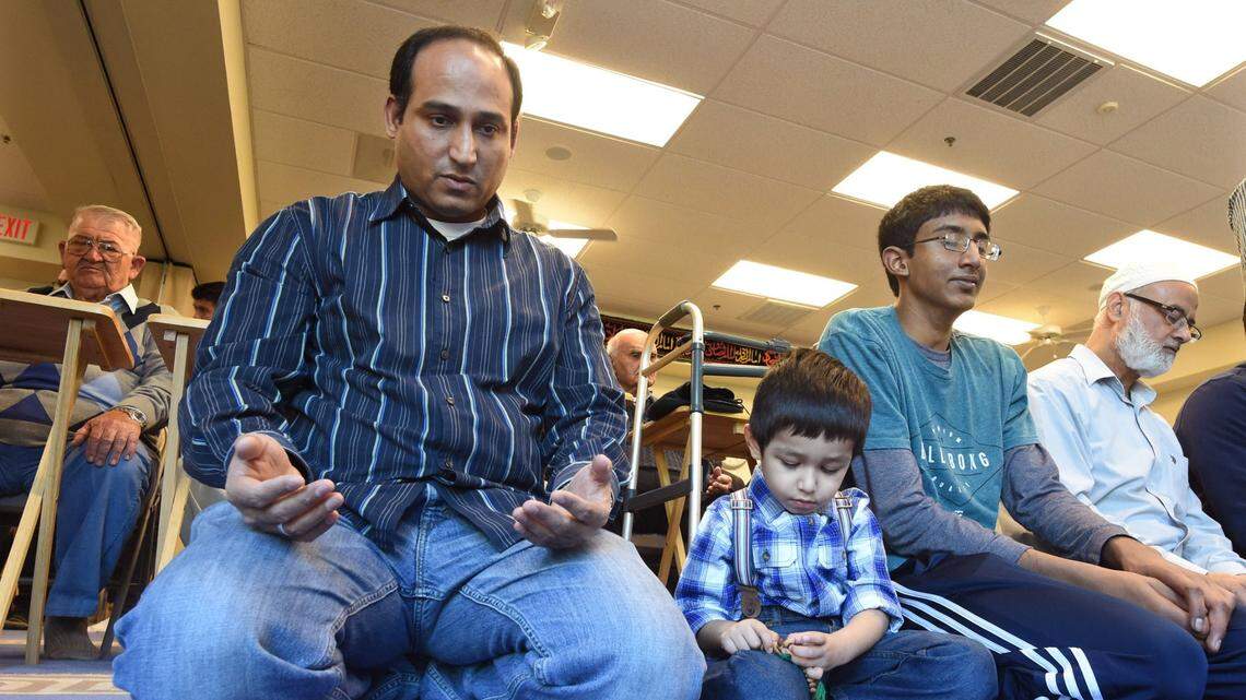 Alamdar Khan prays with son Yaseen Hussain Kham during a Friday service in 2016 at the Islamic Cultural Center of Fresno.
