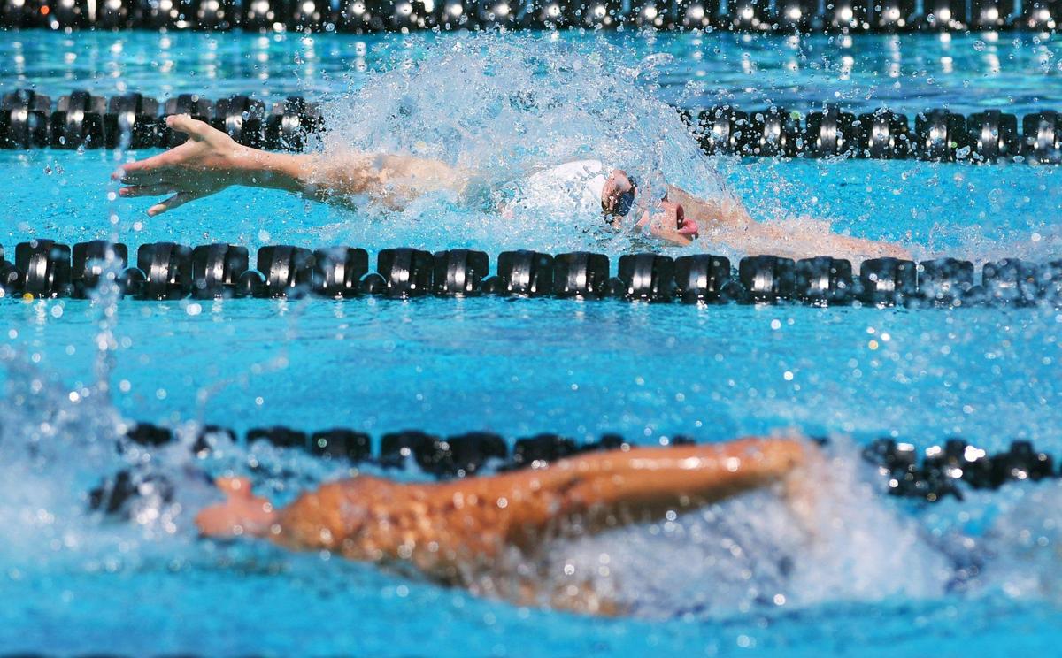 Clovis High’s Colby Villard, top, finishes first in the 5th heat of the Boys 100 Yard Backstroke at the Clovis West Invitational Saturday, April 15, 2023 in Fresno. Clovis Unified’s Olympic Swim Complex at Clovis West opened this week after being closed almost a year for renovation and construction.
