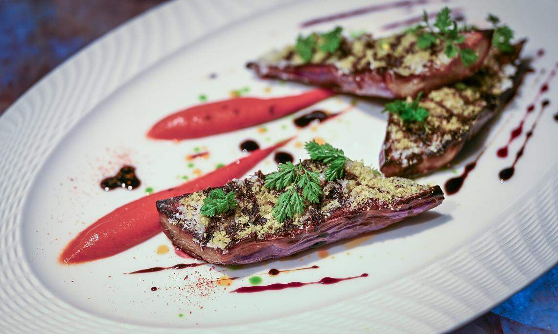 A fire-roasted eggplant dish is plated at Bulle, a new high-end restaurant in northwest Fresno that features farm-to-table dining with a focus on sustainability, in-house dry-aged meats, and seasonal produce.