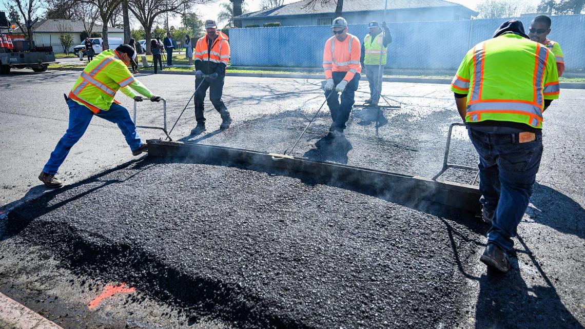 Fresno city work crews work to install a speed bump on Belgravia Avenue near Computech Middle School in Fresno on Monday, Feb. 7.