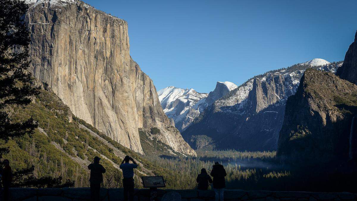 A few park visitors stop to see the El Capitan, left, and Half Dome from Tunnel View in Yosemite National Park after snow dusted the area on Monday, Dec. 9, 2019.