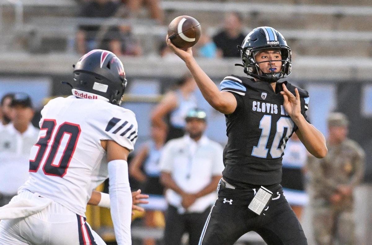 Clovis North quarterback Mario Cosma, right, throws while getting pressure from Memorial’s Mateo Peracchi during their game at Veterans Memorial Stadium in Clovis on Friday, Aug. 18, 2023.