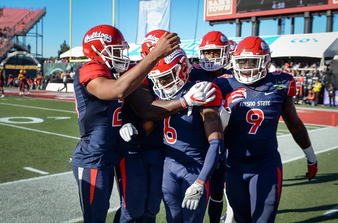 Temmate pile on Fresno State’s Tank Kelly after he scored a pick-six interception and touchdown against Arizona State during their game at the Mitsubishi Las Vegas Bowl at Sam Boyd Stadium in Las Vegas on Saturday, Dec. 15, 2018.