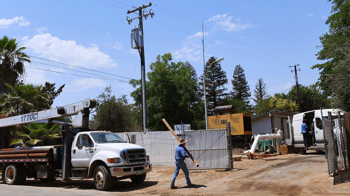 A Madera County Public Works team with help from a contractor repairs a broken pump on the Fender water well last June in Madera Ranchos. Water is a critical source, compounded by housing developments in the area.