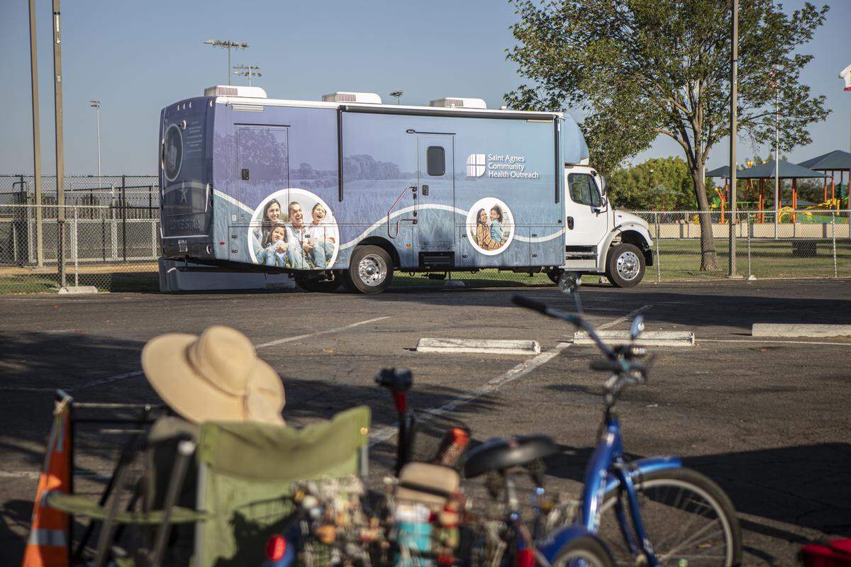 Residents lined up in front of the Saint Agnes Mobile Health Unit mobile clinic parked in the parking lot of Rojas Pierce Park in Mendota on Aug. 28, 2025. Photo by Larry Valenzuela, CalMatters/CatchLight Local