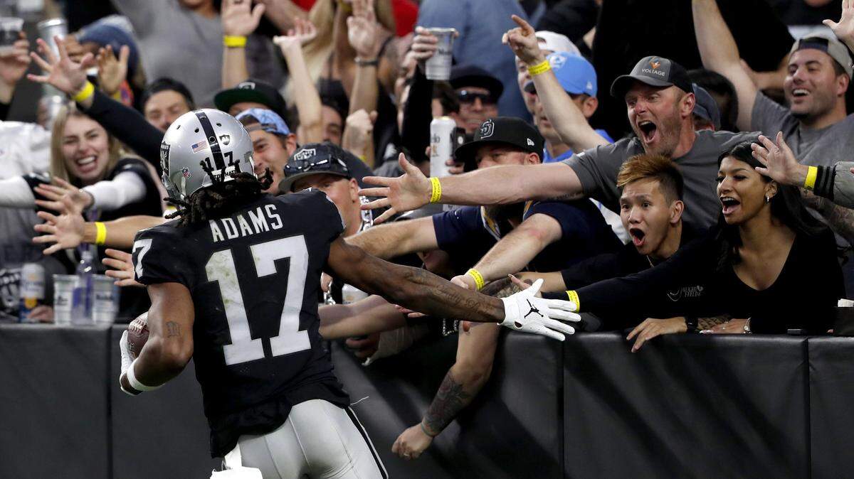Davante Adams of the Las Vegas Raiders celebrates with fans after scoring a touchdown in the third quarter against the Los Angeles Chargers at Allegiant Stadium on Dec. 4, 2022.