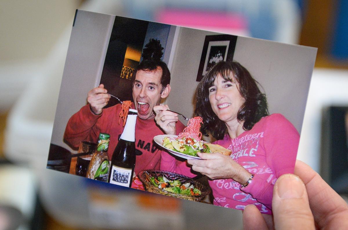 Janine Healy holds a photo of herself and her husband during a Valentine’s Day dinner before he passed away in 2013. Healy will be attending the annual “Widow Mama Valentine Dinner” with other widows as a way of coping with the holiday without their loved ones.