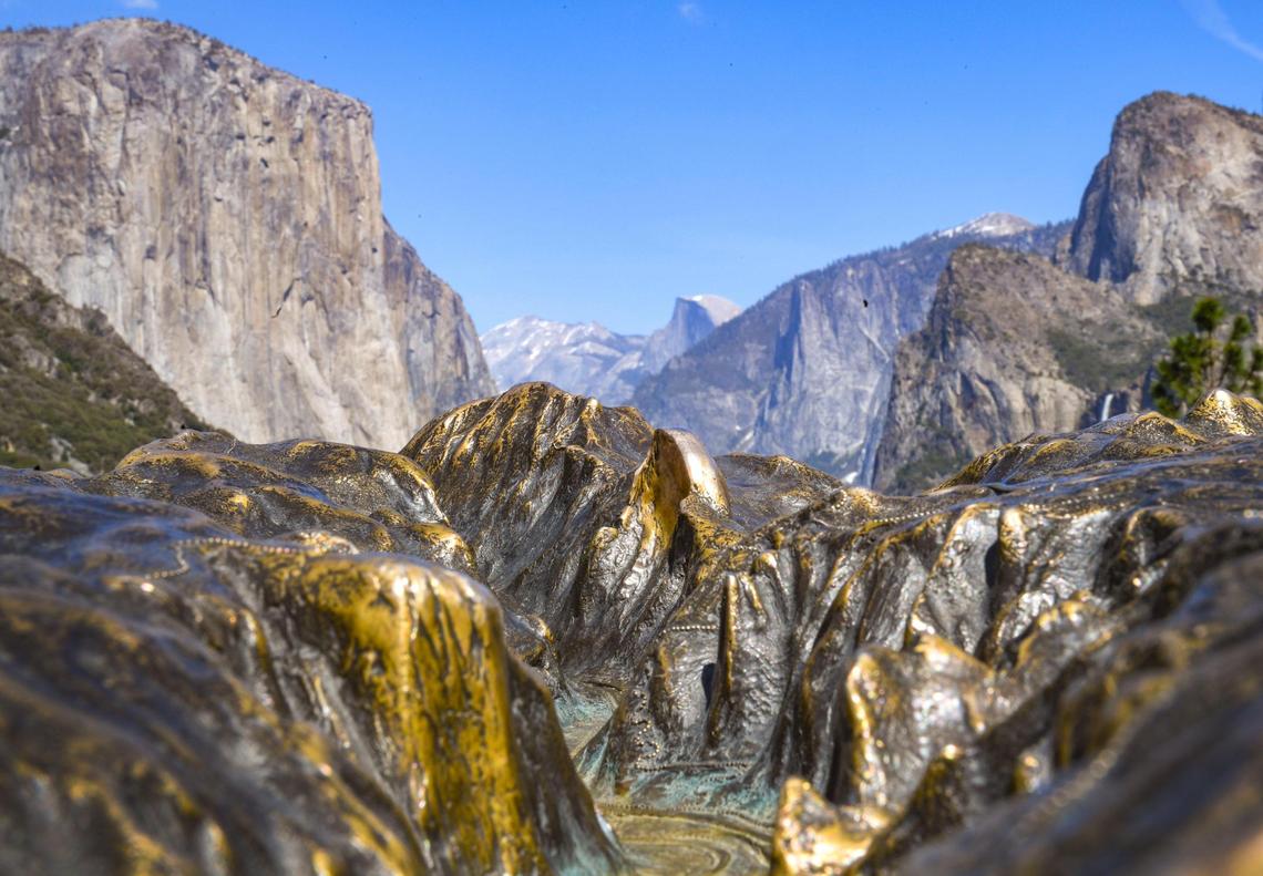 Yosemite Valley is mirrored in the background of a close-up photo of a brass-raised relief map at Tunnel View in Yosemite National Park on Friday, April 23, 2021.