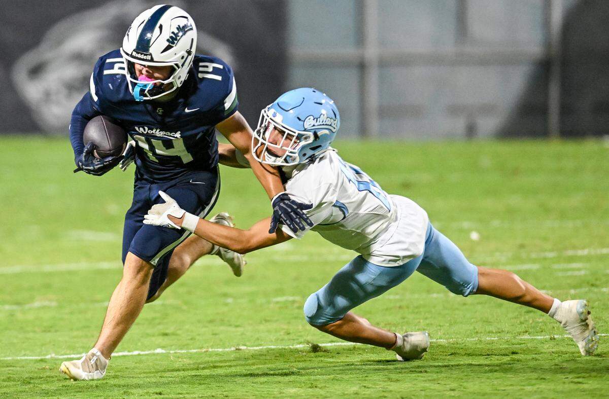 Clovis East’s Frankie McIntire, pushes himself away from Bullard’s Austin Ladd while taking the ball to the outside during their game at Lamonica Stadium on Friday, Aug. 22, 2025.