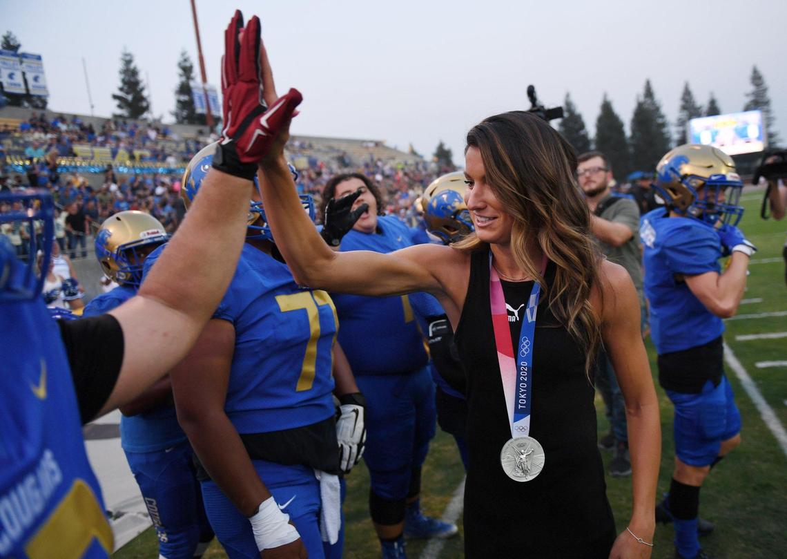 Olympic silver-medalist and Clovis High alum Jenna Prandini high-fives a Clovis player before the Clovis game against Bakerfield Friday, Aug. 27, 2021 in Clovis.