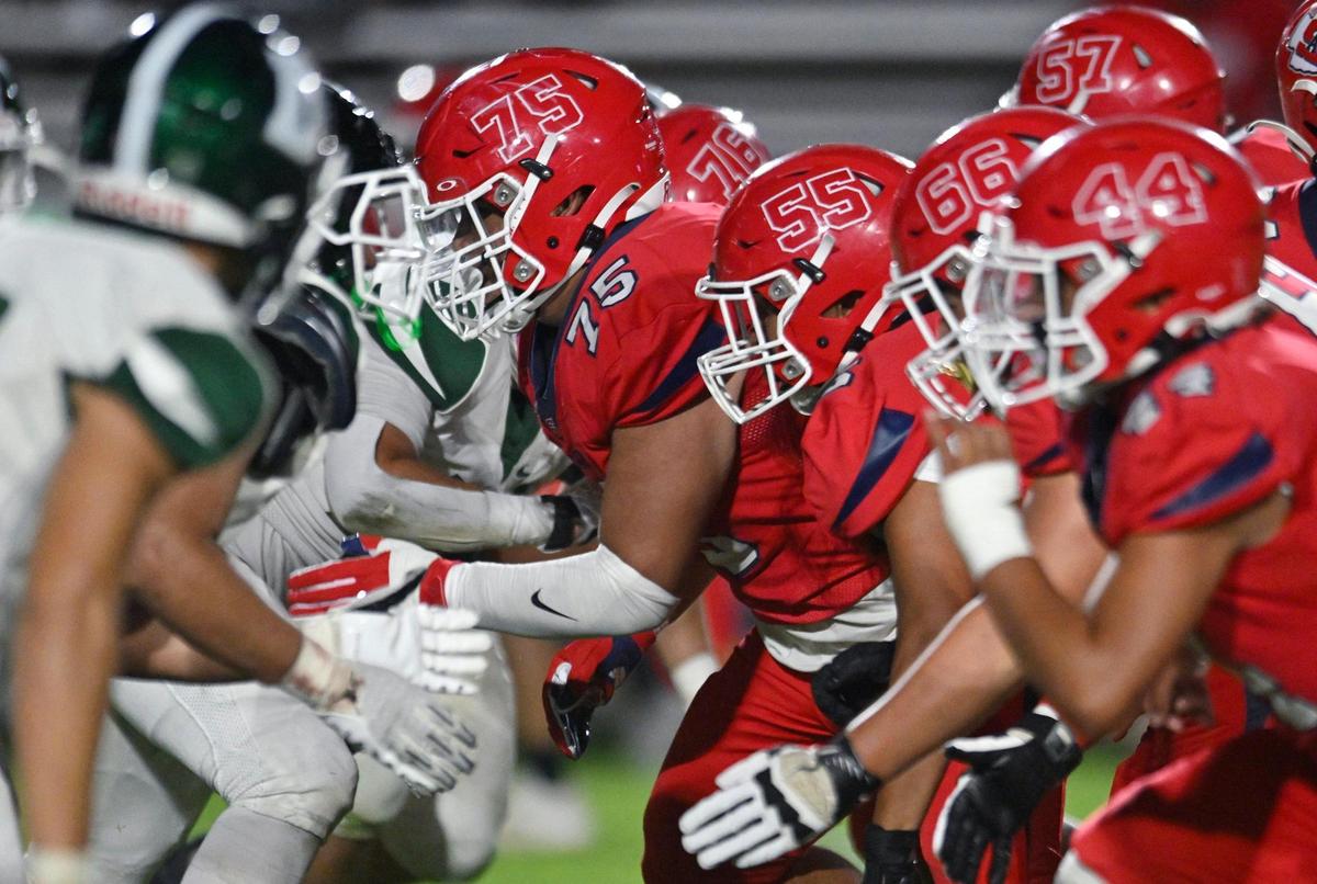 Sanger’s offensive line, right, takes on Dinuba in the second half Friday, Aug. 18, 2023 in Sanger. Final score, Sanger 41, Dinuba 7.