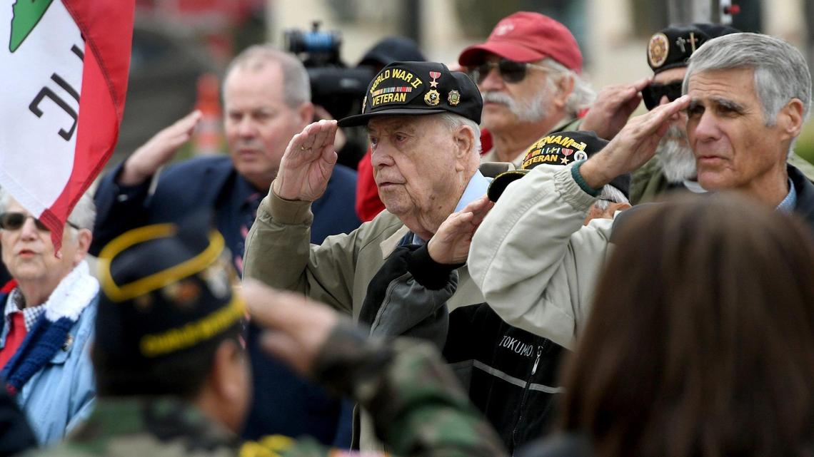 World War II Army infantry veteran Vern Schmidt, 95, of Fresno, center, who served in the European theater of war, salutes during the Pearl Harbor Remembrance Day ceremony at Tesoro Viejo Town Center, Tuesday morning, Dec. 7, 2021. This was the 80th anniversary of the Japanese bombing of Pearl Harbor on Dec. 7, 1941, which led the United States into World War II. The ceremony, attended by around 150, included military veterans, school children, and residents. Bill Tokumoto, 87, was in Honolulu that Sunday morning as a 7 1/2-year-old schoolboy, playing in his backyard, and remembers the waves of Japanese Zeros on their wave in the surprise attack. He said it’s important after 80 years to still remember those who sacrificed their lives on that day that President Franklin Roosevelt said “a date which will live in infamy.” The event featured a keynote speech by Sally Moreno, Madera County District Attorney, musical tributes, a wreath laying, and rifle salute.