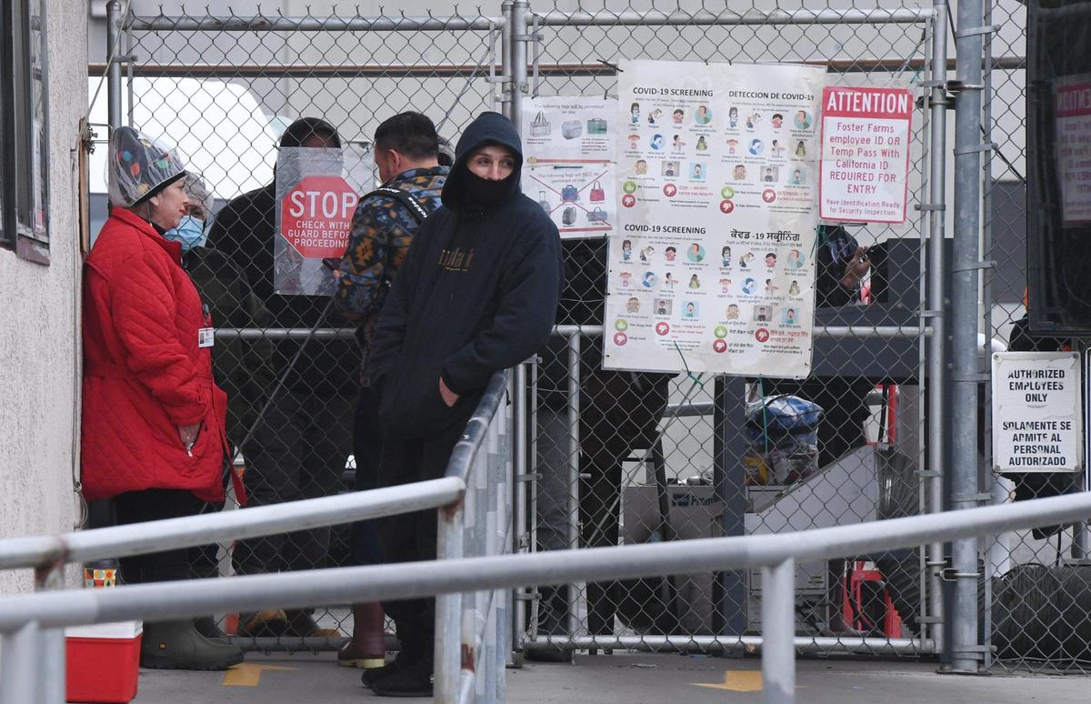 Workers at the Foster Farms facility in southeast Fresno wait outside in the cold as a Fresno Fire HAZMAT team responds to a carbon dioxide leak Friday, Dec. 23, 2022 in Fresno.