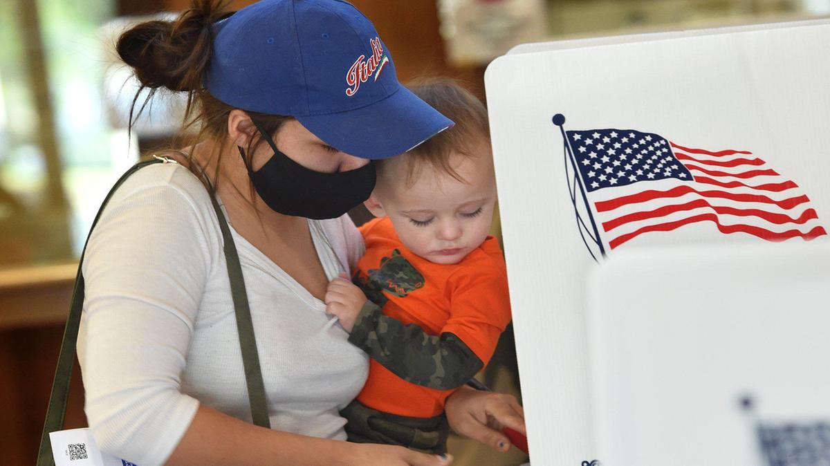 Jenna-Marie Garretson, con su hijo Vincent, de año y medio, deposita su voto en el Clovis Civic Center el día de las elecciones el 3 de noviembre de 2020.