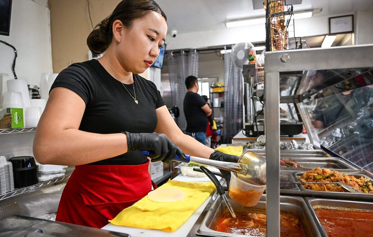 Malee Xiong serves up a bowl of one of the specials for a customer at NyabTee's Kitchen, a new Asian restaurant on First north of Belmont in Fresno. It offers Hmong food but also other Asian influences like Cambodian, Thai and Indian among their dishes.