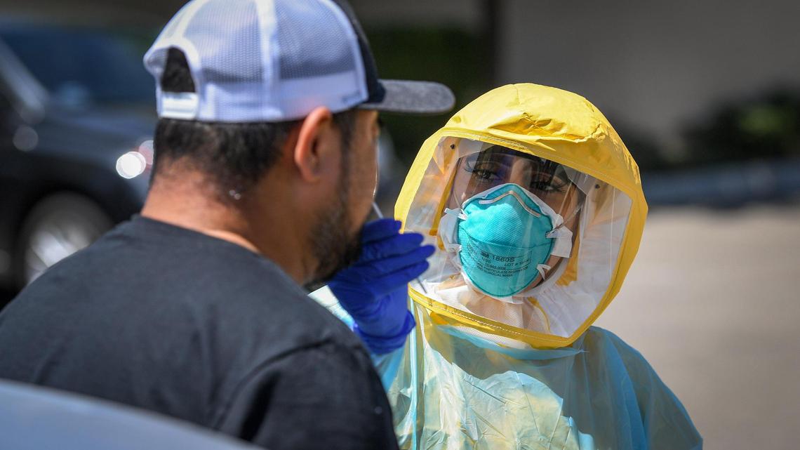 Certified medical assistant Selina Gomez from Clinica Sierra Vista in Fresno, tests a patient for COVID-19 at the drive-up testing area at the facility on Saturday, Aug. 8, 2020. Free COVID-19 testing was made available with an appointment.