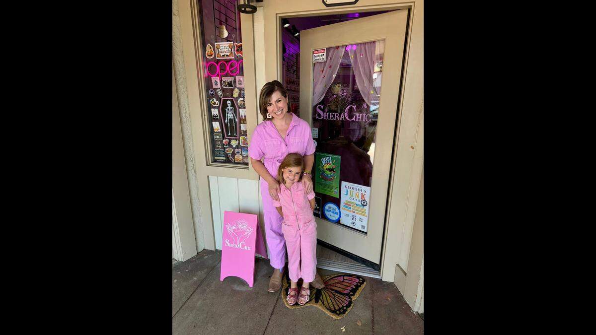 Shera Franzman, owner of SheraChic Boutique in Old Town Clovis, stands in front of her shop with daughter Hazel. The store sells earrings and other jewelry made by Franzman, along with accessories and items from other artists.