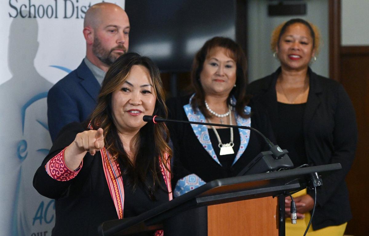 Deputy Superintendent Misty Her, left, points to where she once sat early in her career as she introduces herself as Fresno Unified’s incoming Interim Superintendent at a press conference held Wednesday, May 8, 2024 in Fresno. Current Superintendent Bob Nelson is stepping down effective July 31 for a tenure track faculty position at Fresno State.