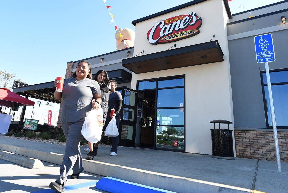 Happy customers leave Raising Canes Chicken Fingers, after the Tuesday morning ribbon-cutting opening, at the site of the old Logans Roadhouse, Blackstone and El Paso avenues.