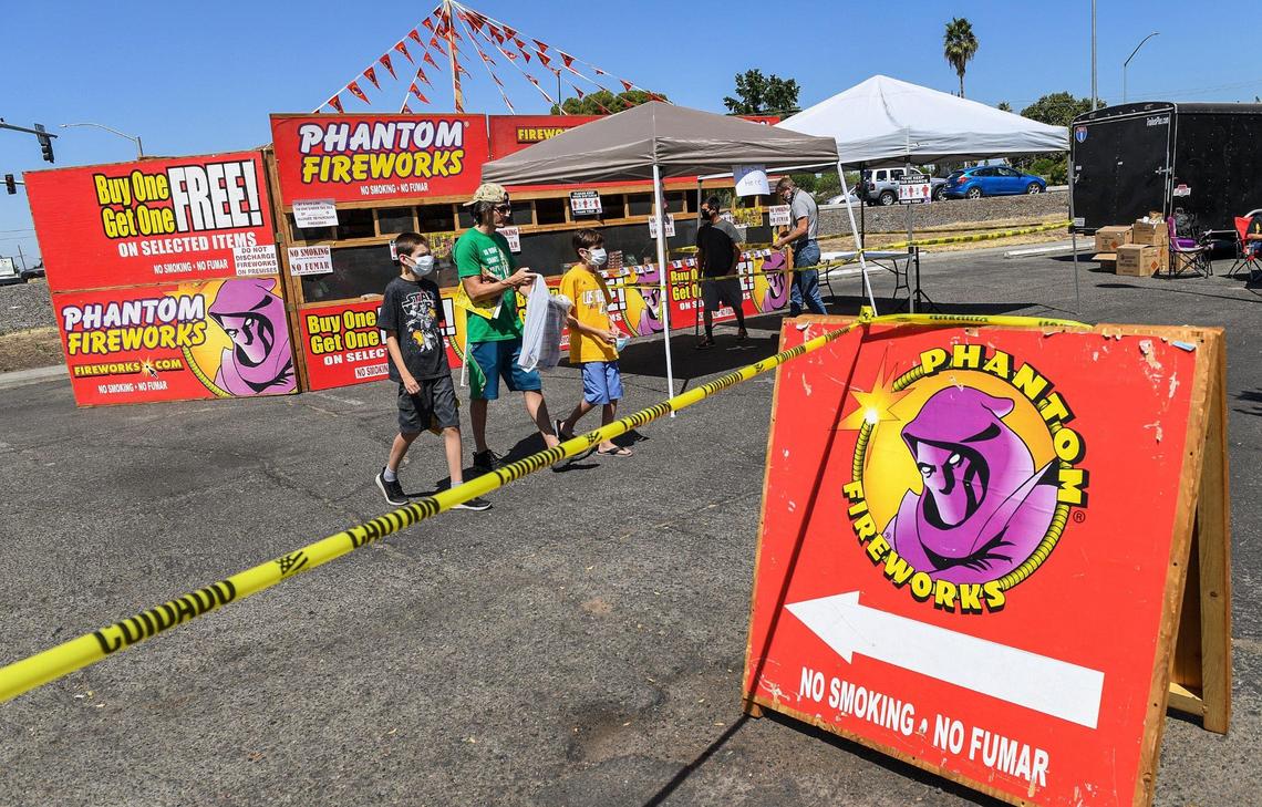 Customers purchase fireworks at the Phantom Fireworks stand being run by the Computech Middle School and Edison High School music programs at Blackstone and Shields avenues in Fresno on Friday, July 3, 2020.