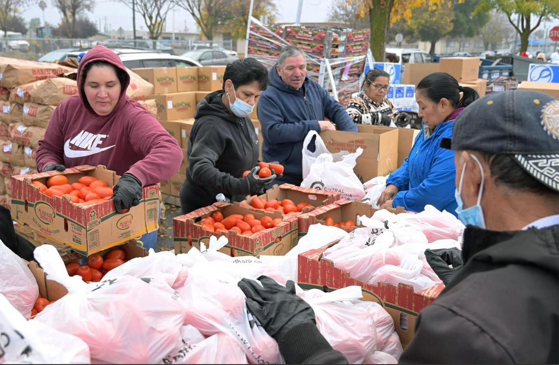 Food is seen sorted and then distributed to community members waiting in line during a Covered California event held in Mendota’s Rojas Pierce Park Thursday morning, Dec. 12, 2024.