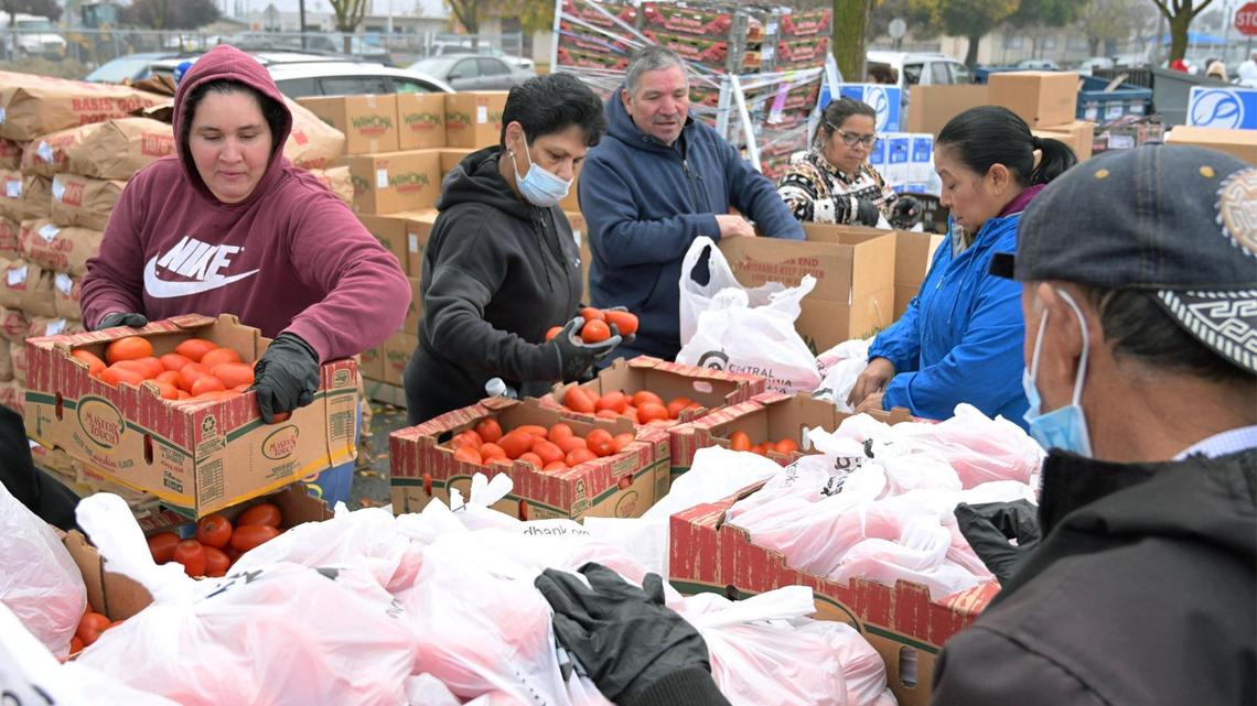 Food is seen sorted and then distributed to community members waiting in line during a Covered California event held in Mendota’s Rojas Pierce Park Thursday morning, Dec. 12, 2024.