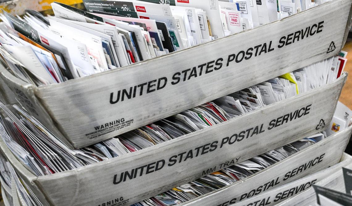 Letters sit in bins to be sorted at a United States Postal Service mail processing center in Fresno in December 2024. Mail delivery will not be affected by the federal government shutdown.