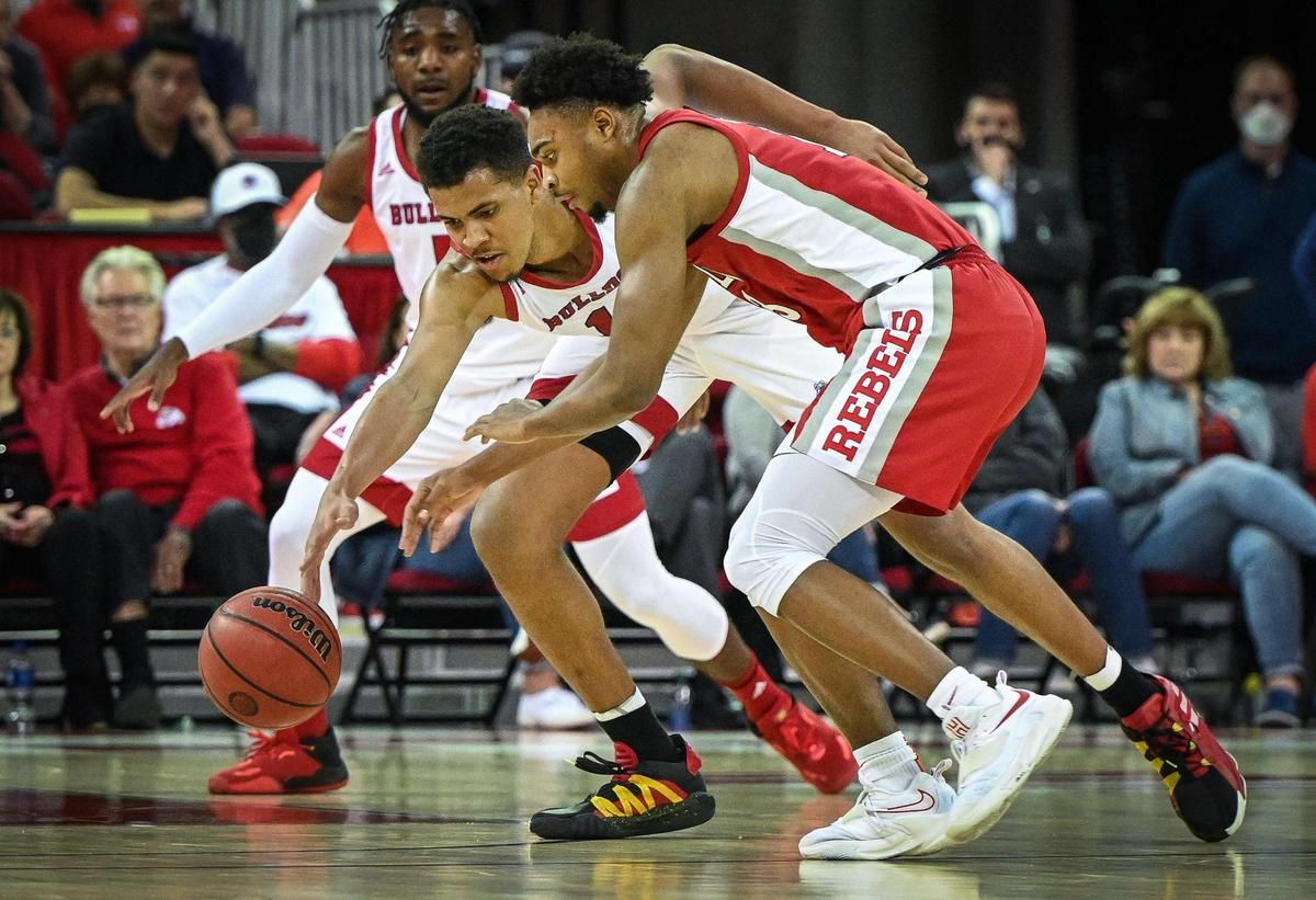 Fresno State’s Orlando Robinson, left, reaches for the ball on an attempted steal against UNLV’s Bryce Hamilton during their game at the Save Mart Center in Fresno on Wednesday, Feb. 16, 2022.