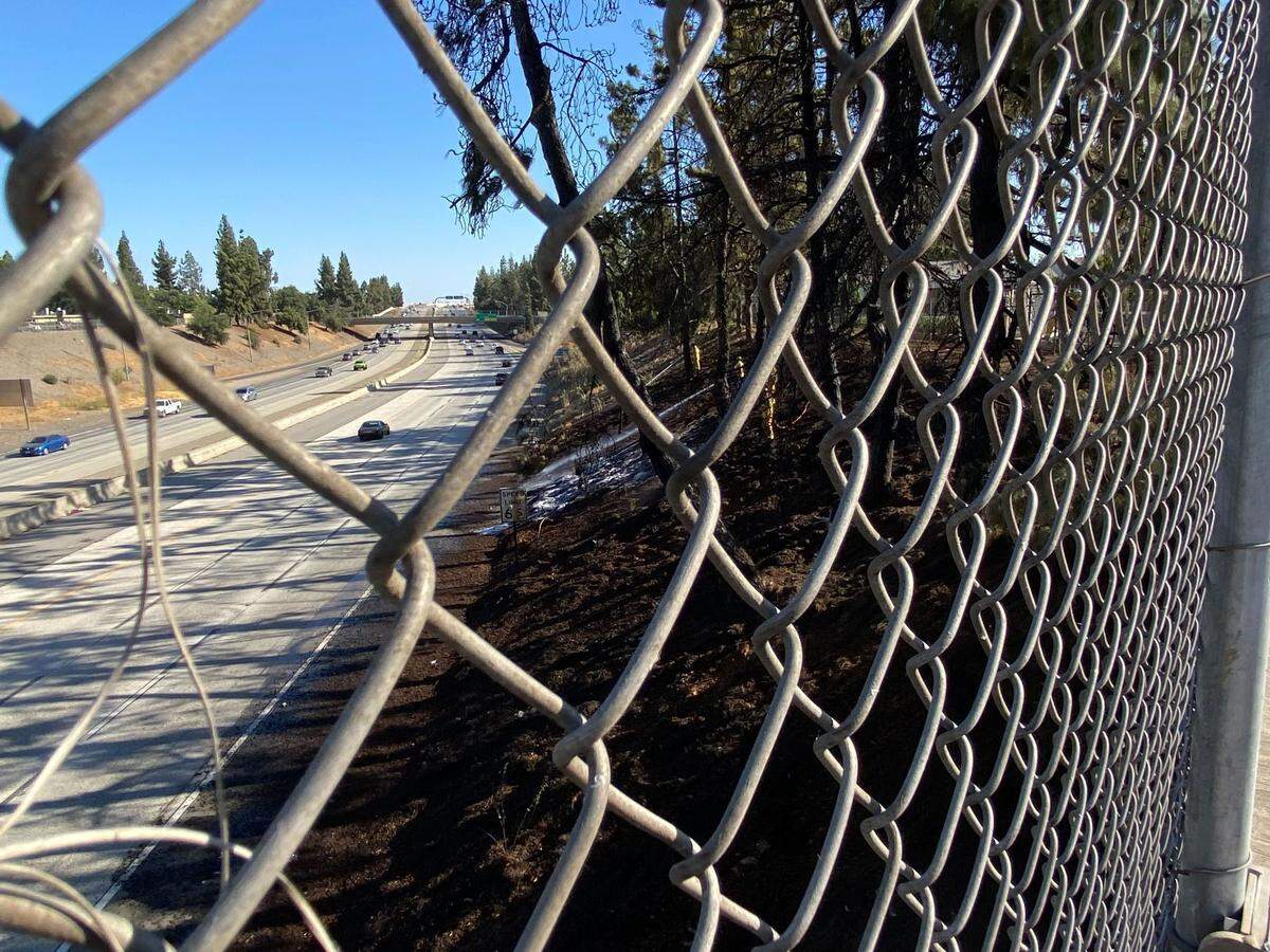 Cars move along southbound Highway 41 after a fire on the embankment slowed the evening commute Monday, July 24, 2023, in Fresno, California.