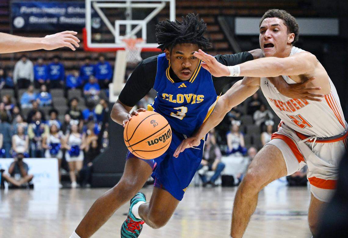 Clovis High's Sier Harbin, center, drives past Atascadero's Damon Mitchell, right, in the CIF Central Section 2025-2026 DII Boys Basketball Championship held Friday, Feb. 27, 2026 at Selland Arena in Fresno.