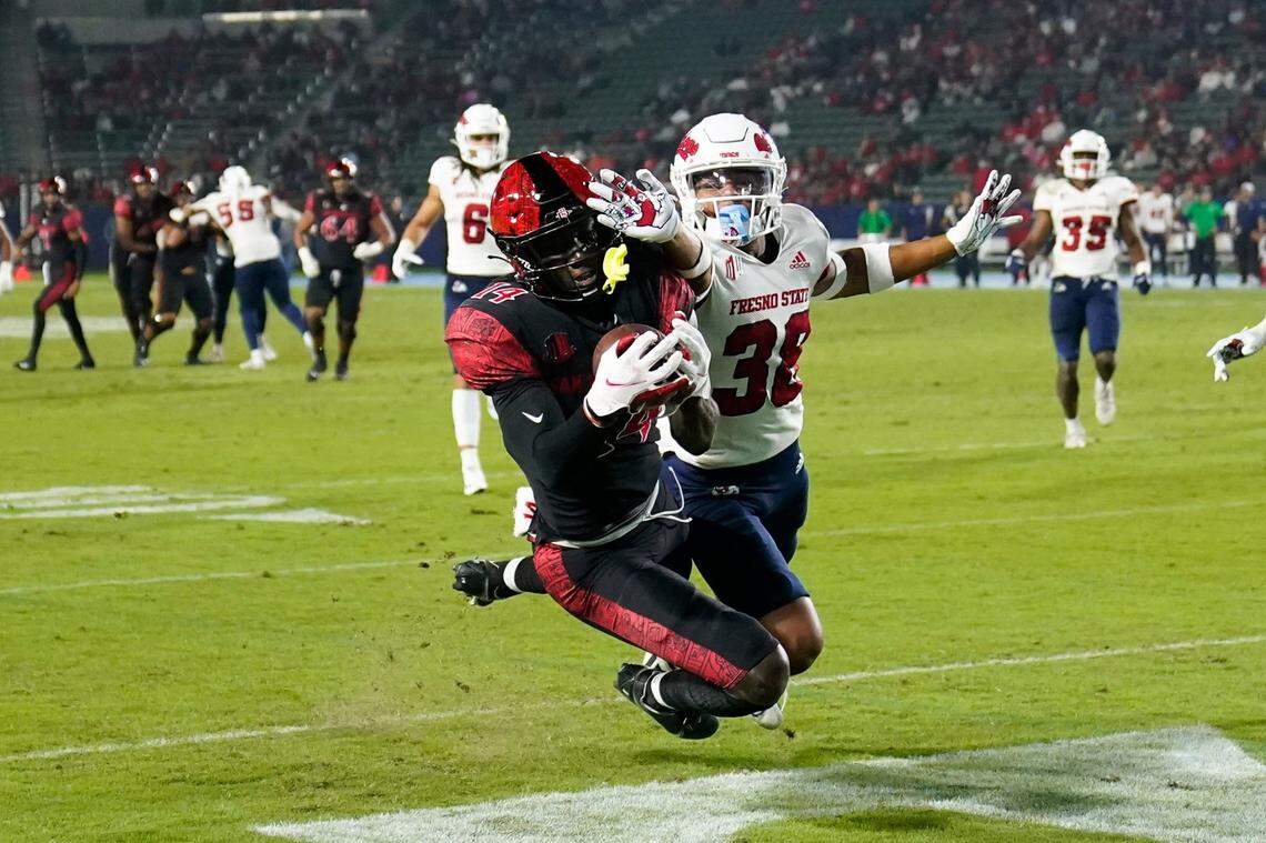 San Diego State’s Tyrell Shavers, left, scores a touchdown against Fresno State’s Bralyn Lux during the first half of an NCAA college football game Saturday, Oct. 30, 2021, in Carson, Calif. (AP Photo/Jae C. Hong)