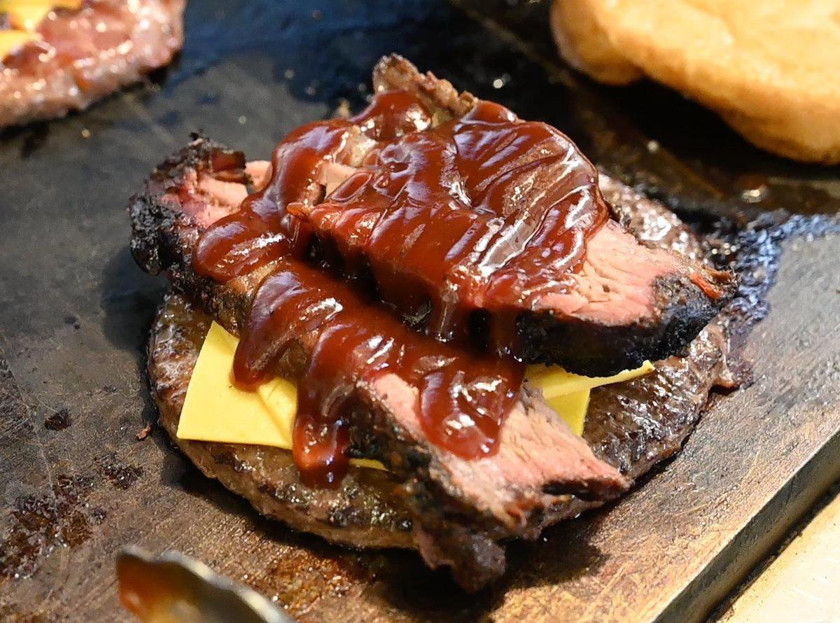 Hamburger topped with smoked tri tip with homemade BBQ sauce The Hotbox BBQ.