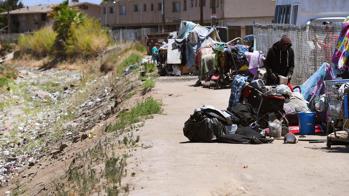 A homeless encampment is seen along Fancher Creek Canal as Fresno Irrigation District workers clear debris before water releases began May 18, 2021 in Fresno.
