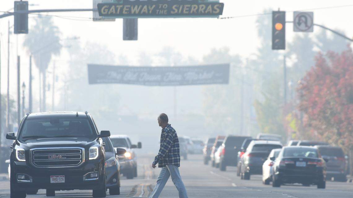A pedestrian crosses Clovis Avenue in Old Town under hazy air Friday morning, Oct. 29, 2021.