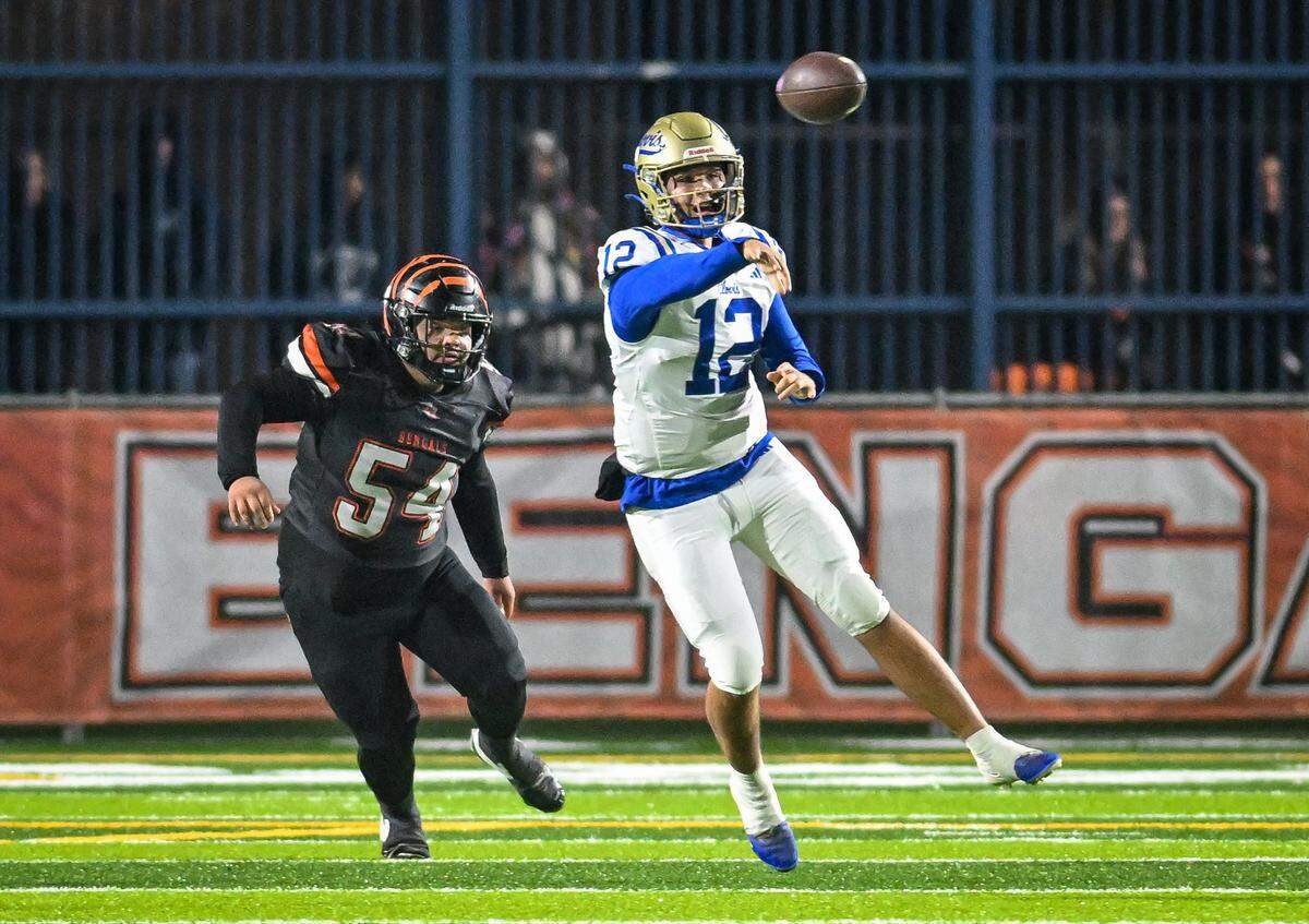 Clovis quarterback Deagan Rose throws while getting pressure from Central East's John Kyle during their Central Section Division I-AA championship game at Deran Koligian Stadium on Friday, Nov. 21, 2025.
