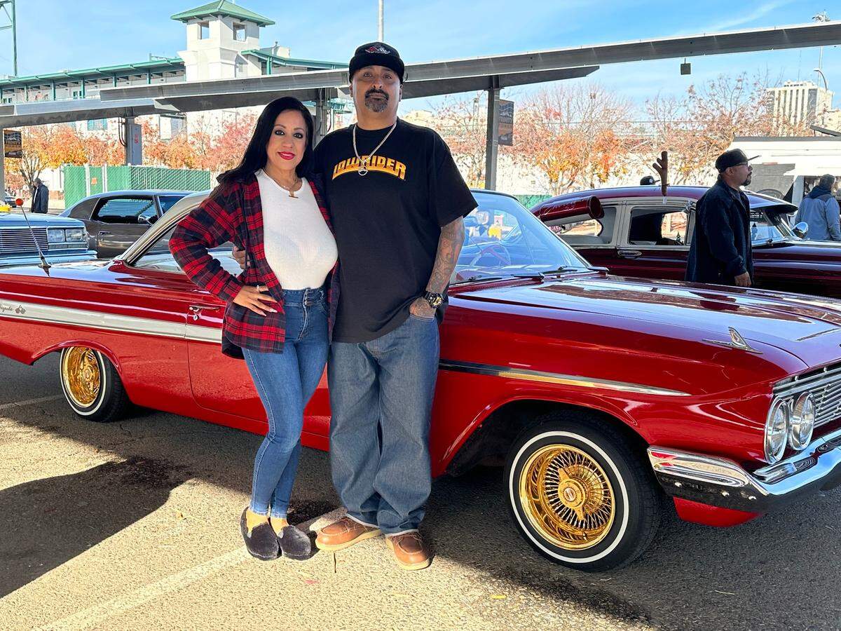 Valerie and Efren Gallardo stand next to her 1961 Chevrolet Impala.