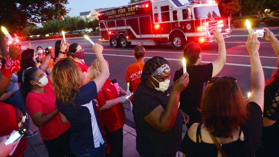 Fresno Fire Department trucks drive by with lights flashing in honor as at least 400 nurses gather on the sidewalk and lawn to hold a candlelight vigil for Kaiser Permanente Fresno Medical Center nurse Sandra “Sandy” Oldfield Wednesday evening, May 27, 2020 in Fresno. Oldfield was exposed to a COVID19 patient. Oldfield, who was 53, died May 25.