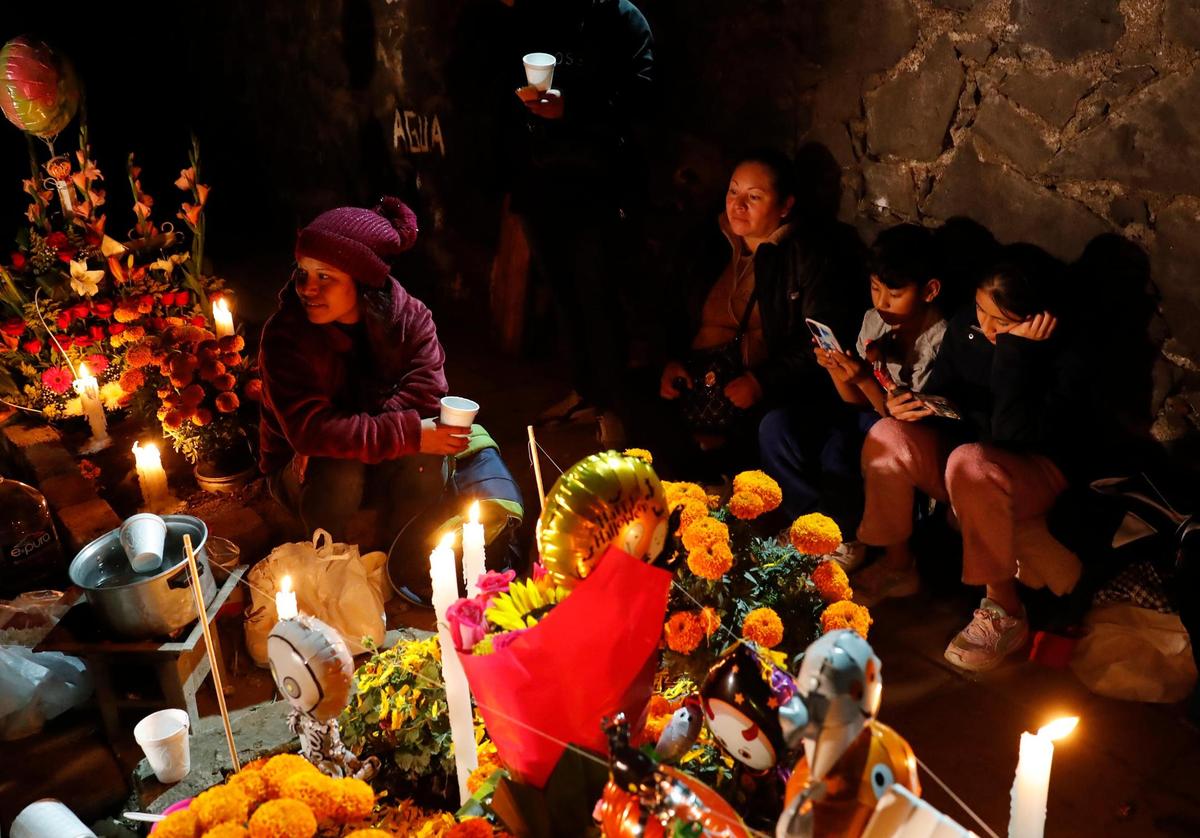 Familiares y amigos visitan a sus fieles difuntos la madrugada de este viernes en el panteón comunal San Gregorio Atlapulco, en la Ciudad de México (México). La festividad más emblemática de México, el Día de Muertos, arrancó este viernes de madrugada, y en el pintoresco barrio de Xochimilco, en la capital mexicana, los colores y olores tradicionales de estas fechas se mezclan en una especial simbiosis con la colocación del altar de San Gregorio. 
