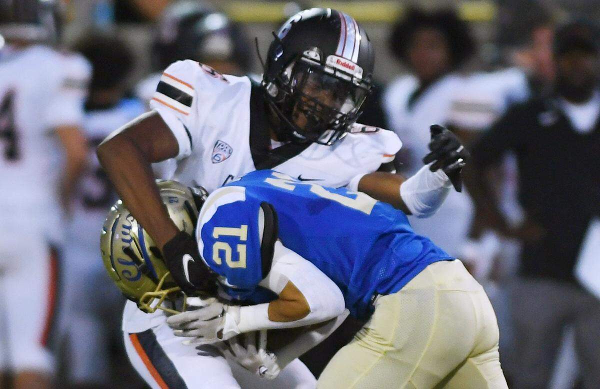 Clovis High’s Tyler Marquez, foreground, is tackled by Central’s Jaylon Jones, background, in first quarter action Thursday, Sept. 29, 2022 in Clovis.