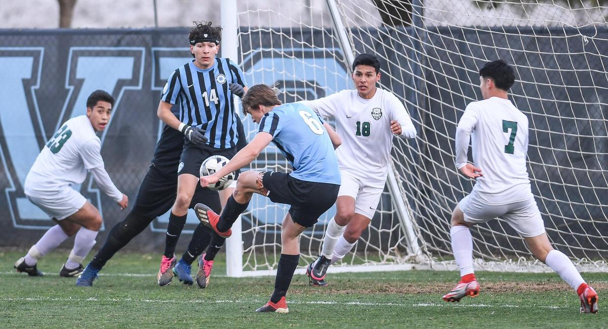 Clovis North’s Steven Mohr, center, kicks the ball at the Reedley goal for the first score of the game during their match at Clovis North on Tuesday, Feb. 22, 2022.