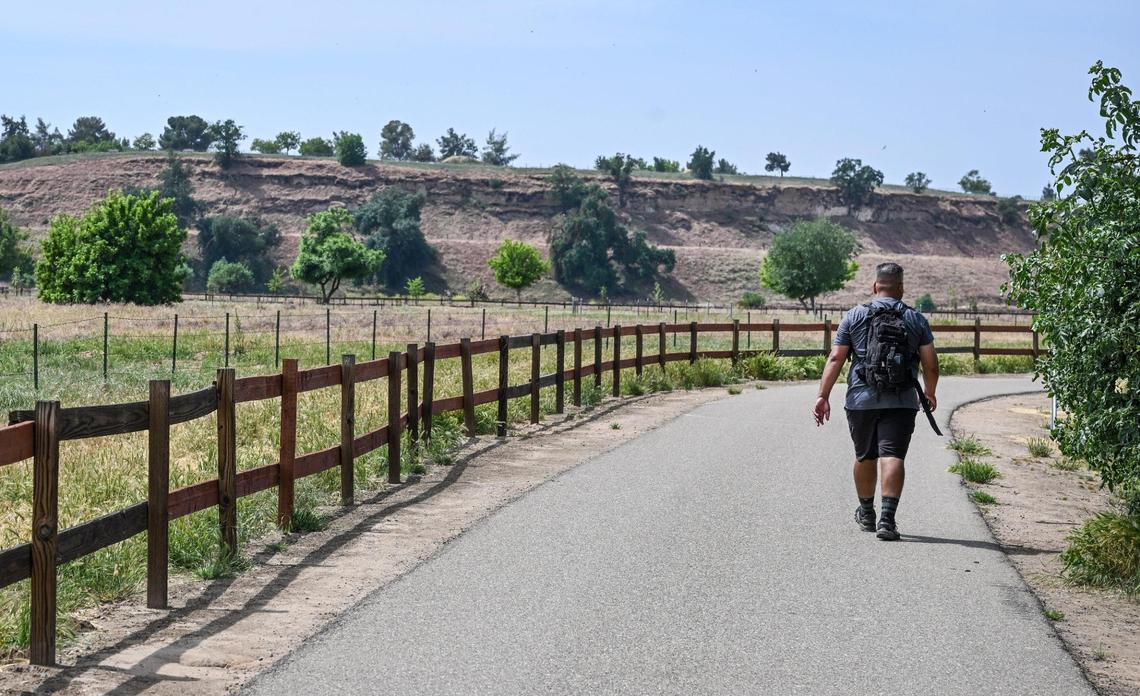 A man walks along one of the river access trails in the San Joaquin River Conservancy’s Jensen River Ranch area next to the San Joaquin River and just to the north of Woodward Park in Fresno on Wednesday, April 20, 2025.